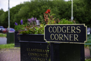 Picture of a planter behind a sign for Codgers Corner